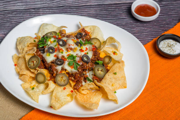 comida mexicana famosa carne moída picante nachos. chips de tortilla crocante aquecidos com queijo derretido e jalapeno servido um lanche. - chili pepper guacamole food beer - fotografias e filmes do acervo