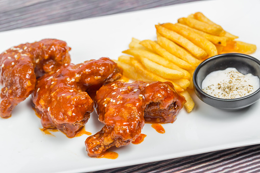 Hot and spicy buffalo chicken wings and crispy french fries with white sauce.