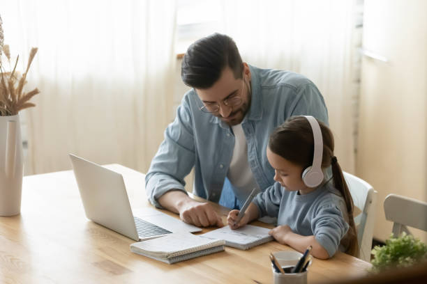 istock Daddy helping small 7s old kid daughter preparing homework. 1272542084