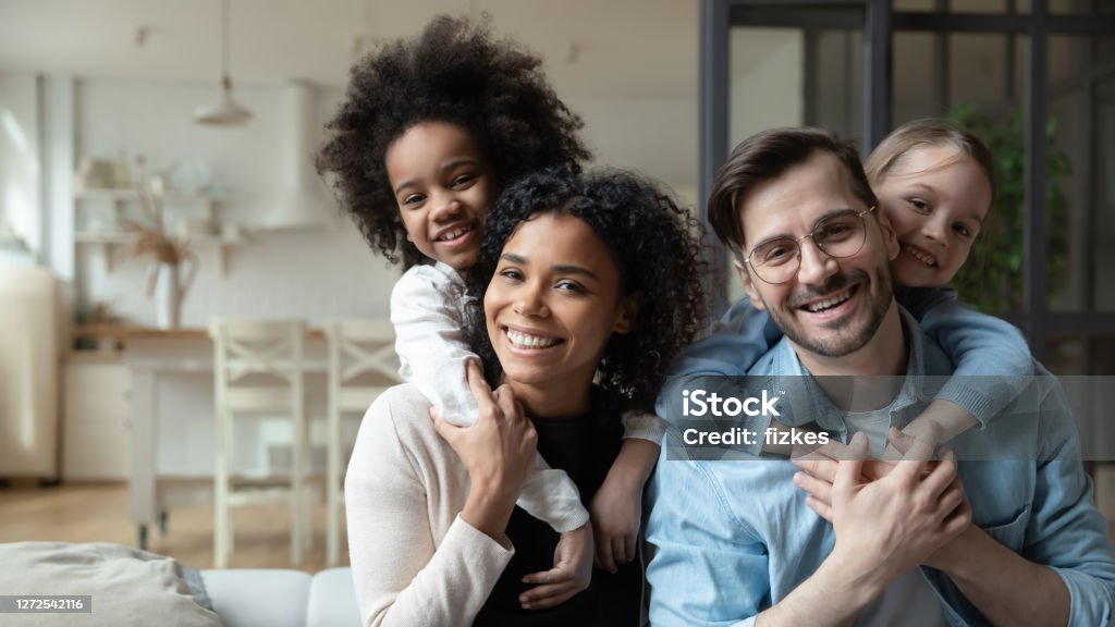 快樂的多種族夫婦享受甜蜜的家庭時刻與孩子。 - 免版稅家庭圖庫照片