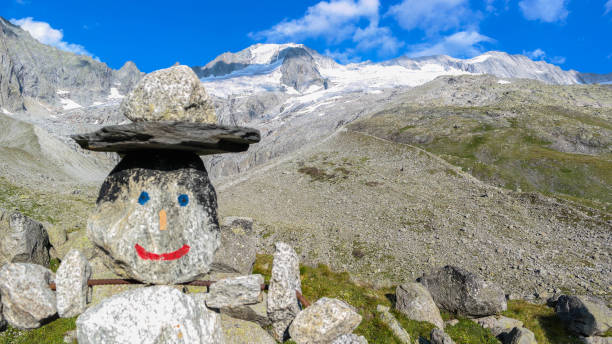 homem de pedra em frente a uma montanha alta e maciça - tirol rock gravel mountain peak - fotografias e filmes do acervo