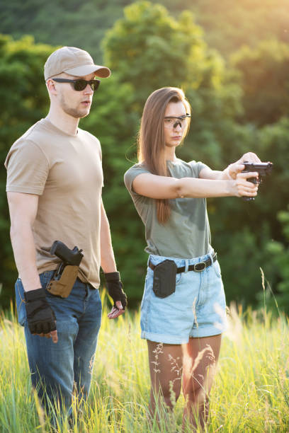 istock A girl learns to shoot a pistol with an instructor at the training ground 1272546167