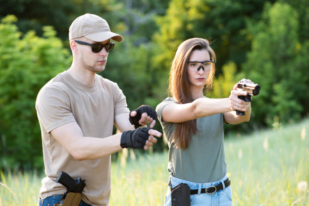 istock A girl learns to shoot a pistol with an instructor at the training ground 1272546176