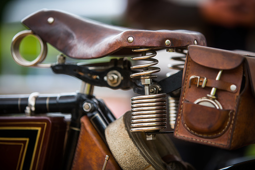 Close up shot of a vintage motorcycle leather saddle and toolbox.