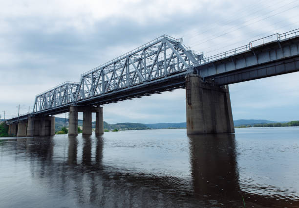 istock Railway bridge over the river against a cloudy sky. 1272546727
