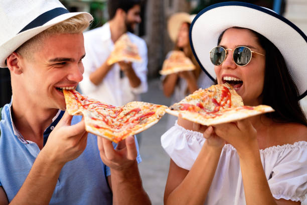 istock Group of friends eating pizza while traveling on vacation 1272549992