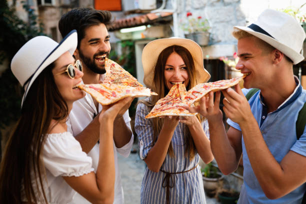 istock Group of friends eating pizza while traveling on vacation 1272550003
