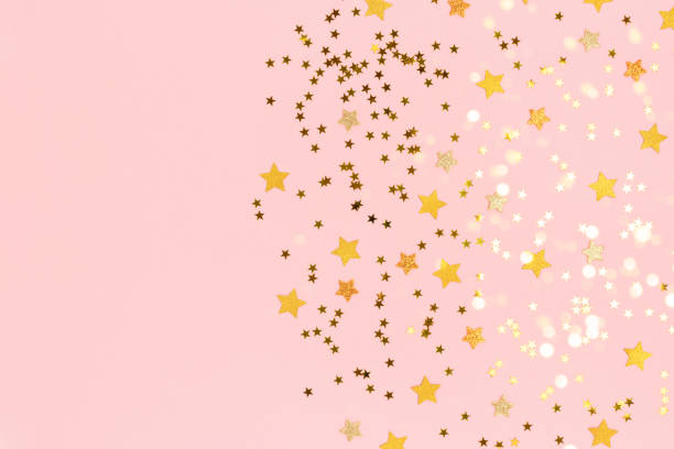 istock Gold stars confetti scattered on a pink pastel background. 1272551765