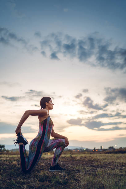 istock Woman doing yoga on meadow 1272553175