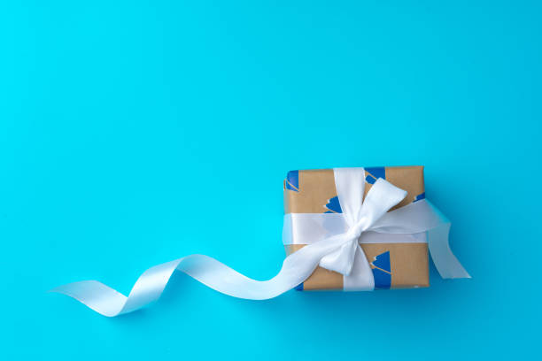 istock Top view of gift box with ribbon on blue background 1272553290