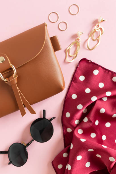 Top view of women's accessories on pink background