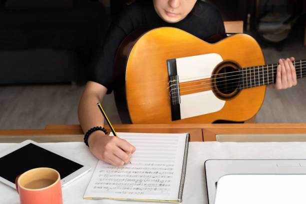 istock Little girl studying guitar from home and taking notes 1272556983