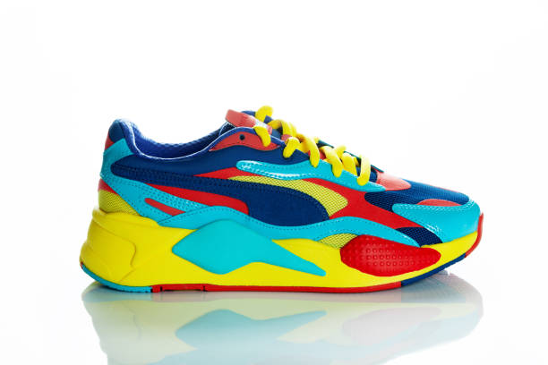 istock Multicolor sport shoes on yellow background with shadows 1272557390