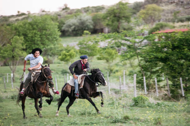 istock Young gauchos grinning while racing on horseback 1272558666