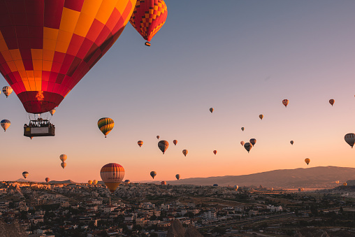Cappadocia / Turkey - September 14, 2020: Flying hot air balloons and rock landscape at sunrise time in Goreme, Cappadocia, Turkey