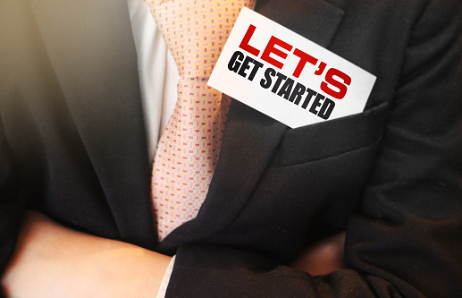 Businessman hold caerd with text Let us get started text on it. Business concept.
