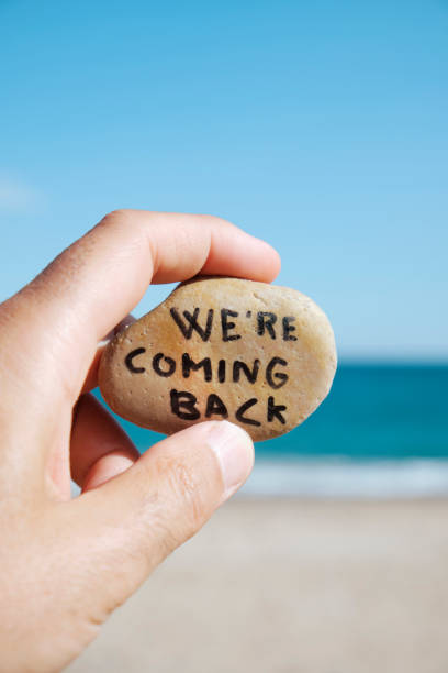 istock man on the beach and text we are coming back 1272562057