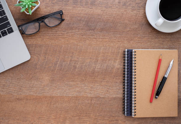istock Wooden office desk table with keyboard, notebook and coffee cup with equipment other office supplies. Business and finance concept. Workplace, Flat lay with blank copy space. Top view 1272563574