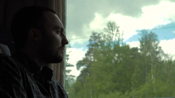istock Caucasian man in a train in daytime, looking out window 1272563731