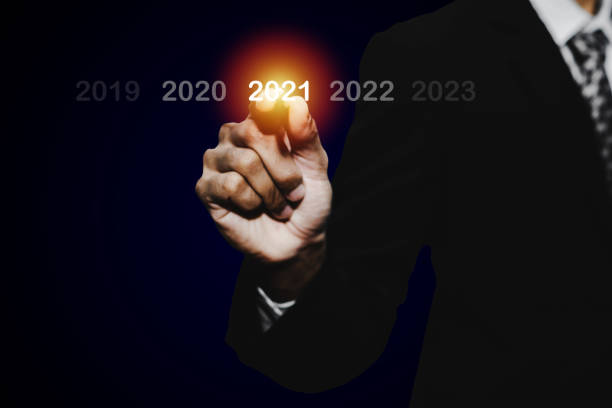 istock Goal target. businessman hand touching and pointing with pen on year 2021 with virtual screening on dark background, change from 2010 to 2021, strategy, business planning and happy new year concept 1272565238