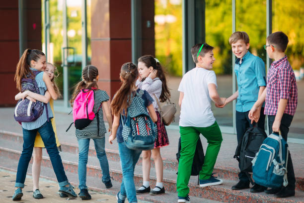 istock Schoolmates go to school. Students greet each other. 1272567847