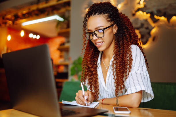 istock Young freelancer woman using laptop computer sitting at cafe table. 1272568140