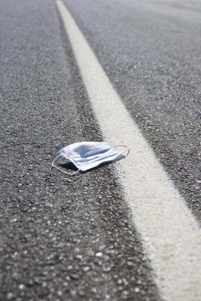 istock Protective medical mask thrown on the asphalt  road 1272569599