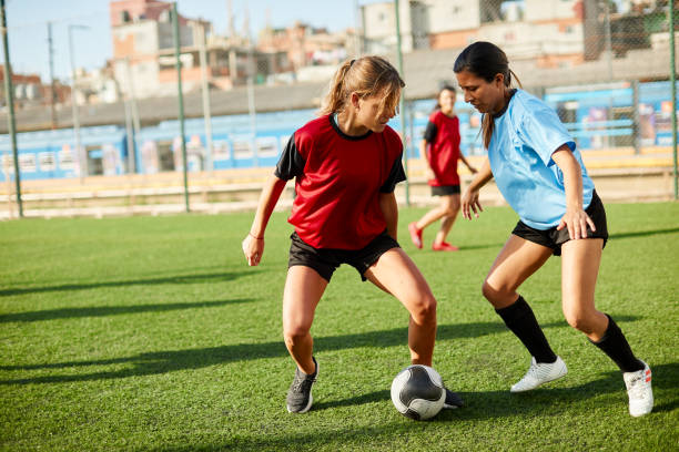 istock Female soccer player dribbling an opponent defender. 1272572530