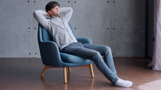 Happy man relaxing on comfortable armchair, smiling calm relaxed guy lounge eyes closed in sunny cozy home Happy man relaxing on comfortable armchair, smiling calm relaxed guy lounge eyes closed in sunny cozy home man sleeping chair stock pictures, royalty-free photos & images