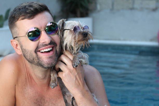 uomo con il suo cane in piscina - underwater dog adult happiness foto e immagini stock