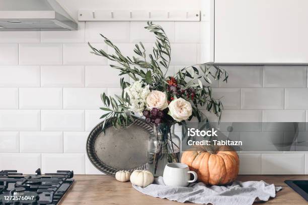 Autumn Still Life Composition In Rustic Eclectic Kitchen Interior Cup Of Coffee Vintage Silver Tray And Floral Bouquet Wooden Table Background With Pumkins Thanksgiving Halloween Concept Stock Photo - Download Image Now