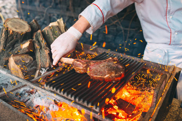 istock Chef Cooking steak. Cook turns the meat on the fire. 1272576863