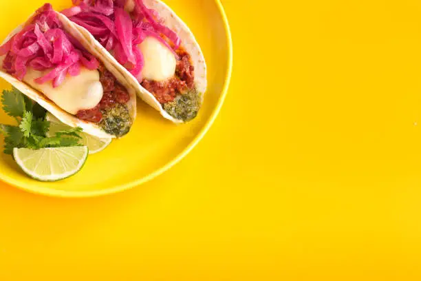 Mexican tacos on yellow plate and background. Overheadshot