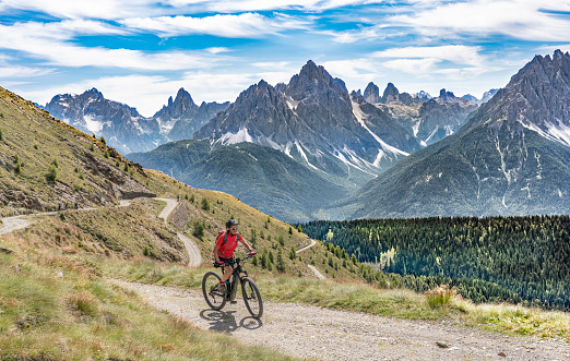 woman with electric mountain bike on old military road in the Dolomites