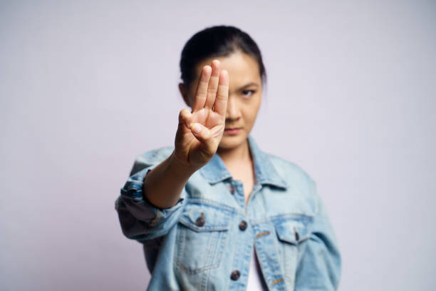 istock Asian woman showing three finger isolated over white background. 1272578484