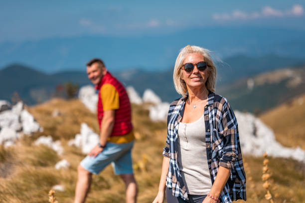 Mature adult caucasian couple walking in mountains on a beautiful sunny summer day.
