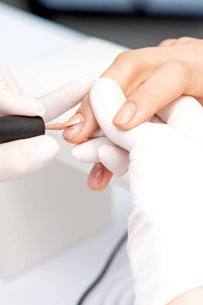 istock Manicure master applying beige nail polish 1272580704