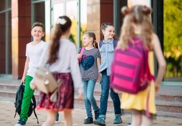 istock Schoolmates go to school. Students greet each other. 1272586639