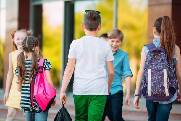 istock Schoolmates go to school. Students greet each other. 1272586660
