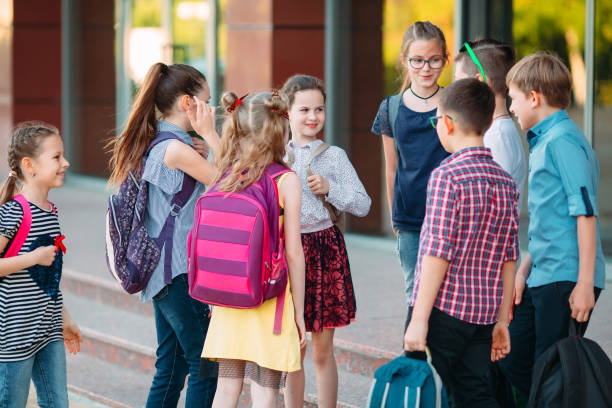 istock Schoolmates go to school. Students greet each other. 1272586711
