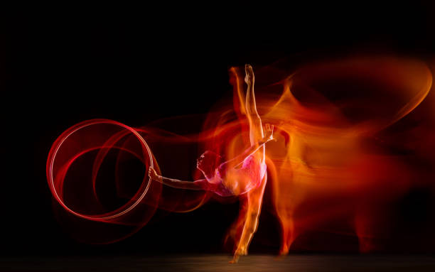 istock Young flexible female gymnast isolated on black studio background in mixed light, 1272587180