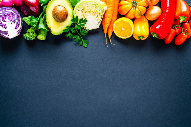Healthy rainbow colored vegetables frame on black background. Overhead view