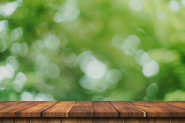 istock Empty wood table and green bokeh blur with copy space display montage for product. 1272588364