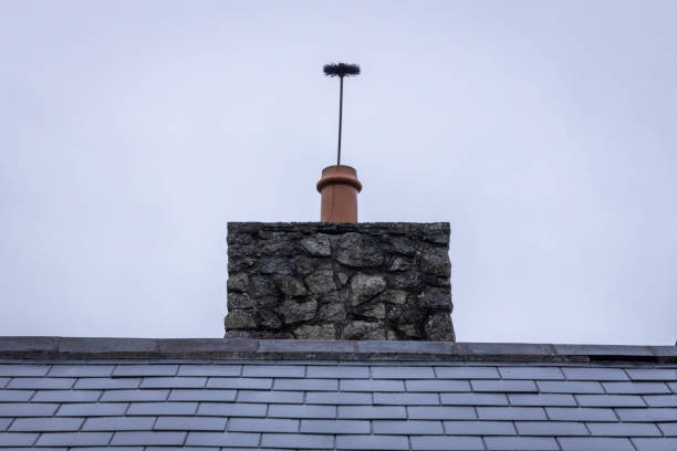 chimney cleaning brush sticking up out of a chimney pot - straight on - chimney sweeping imagens e fotografias de stock