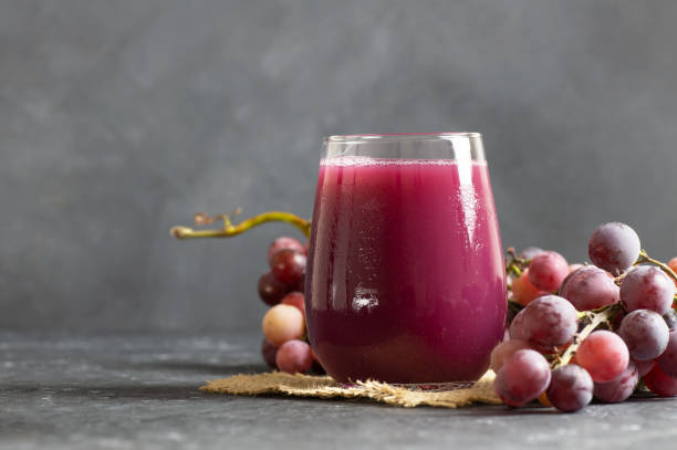szklanka czarnego lub czerwonego soku z kompotów z owoców winogron ze świeżymi winogronami, koncepcja ekologicznego zimnego napoju owocowego, oryginalny kolor - red grape grape fruit sweet food zdjęcia i obrazy z banku zdjęć