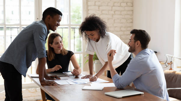 istock Happy multiethnic colleagues brainstorm discuss paperwork at meeting 1272592652
