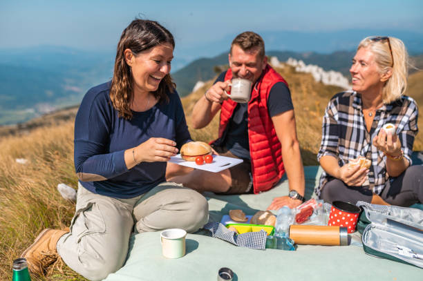 istock Three adult people having picnic in mountains 1272593981