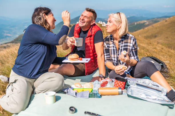 istock Three adult people having picnic in mountains 1272593984