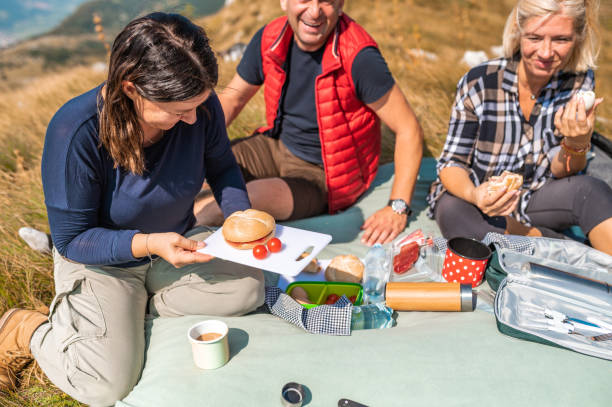 istock Three adult people having picnic in mountains 1272594036