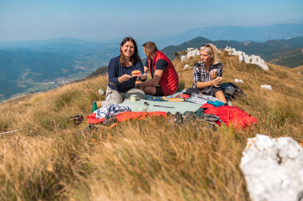 istock Three adult people having picnic in mountains 1272594128